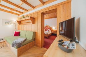 a living room with a tv and a couch in a room at Almkönig in Maria Alm am Steinernen Meer