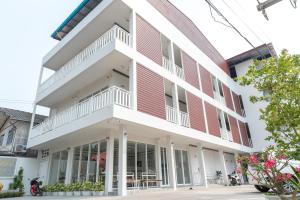 un edificio de ladrillo blanco y rojo en Siri Ville Hotel, en Sisaket