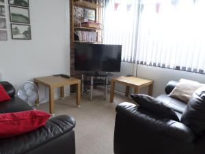 a living room with a couch and a flat screen tv at Lighthouse Chalet in Lowestoft