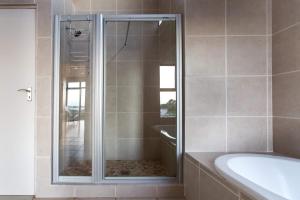 e bagno con doccia, vasca e vasca. di Gecko House a Pringle Bay