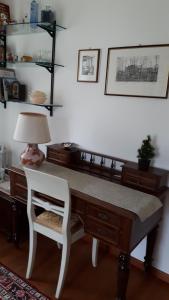 a desk with a lamp and a white chair next to it at B&B LE ORTENSIE in Castagnole