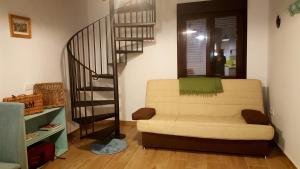 a living room with a couch and a spiral staircase at El Loft de Dulcinea: en el corazón de El Toboso. in El Toboso