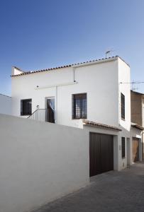 una casa bianca con una recinzione di El Loft de Dulcinea: en el corazón de El Toboso. a El Toboso