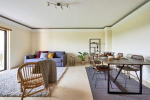 uma sala de estar com uma mesa e um sofá em Carcavelos Apartment em Carcavelos
