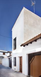 una casa bianca con garage di El Loft de Dulcinea: en el corazón de El Toboso. a El Toboso