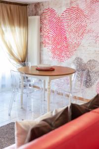 リーヴァ・デル・ガルダにあるRivApartmentsDowntowN Loveの壁にハートが付いた部屋内のテーブルと椅子