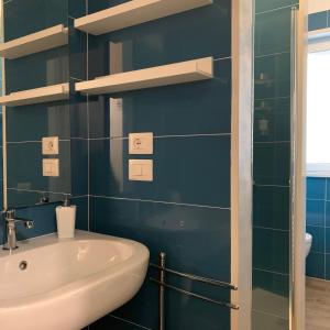 a blue bathroom with a sink and a toilet at Palazzo Ducale in San Severo +70 photos
