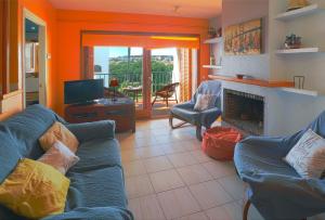 サガロにあるJardins de S'agaro per 6 pax, piscina comunitaria y parking E32235のリビングルーム(青いソファ、テレビ付)