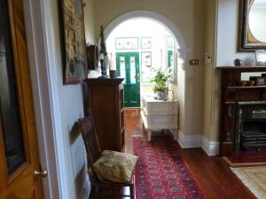 un pasillo con un arco, una silla y una puerta en Lakeside Bed & Breakfast, en Perth