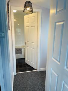 a hallway with a white door and a bathroom at The Garden Room in Filey