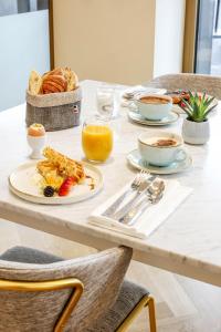 - une table de petit-déjeuner avec une assiette de nourriture dans l'établissement Hotel des Vosges BW Premier Collection, à Strasbourg
