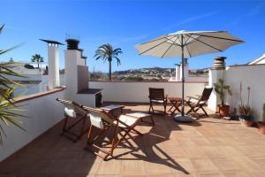 un patio con mesa, sillas y sombrilla en E32123 jardins de s'agaró, en S'Agaró