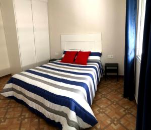 a bedroom with a large bed with red pillows at Apartamentos MareaBeach in Torremolinos