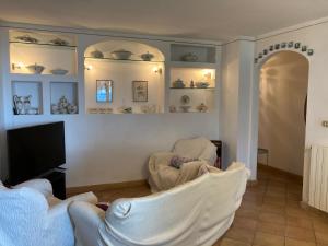 ein Wohnzimmer mit 2 Stühlen und einem Flachbild-TV in der Unterkunft Villa Provenzale in Sanremo