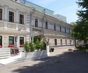 a large white building with a table and chairs in front of it at Sverchkov 8 Hotel in Moscow