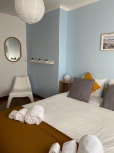 a bedroom with a large bed with towels on it at Casa São Francisco in Porto Covo