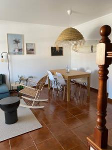 ein Wohnzimmer mit einem Tisch und Stühlen in der Unterkunft Casa São Francisco in Porto Covo