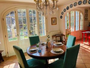 een eetkamer met een houten tafel en groene stoelen bij Villa Provenzale in Sanremo