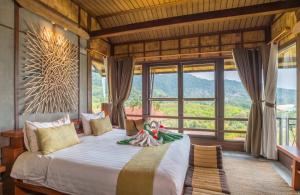 une chambre avec un grand lit avec une grande fenêtre dans l'établissement Alama Sea Village Resort - SHA Extra Plus, à Ko Lanta