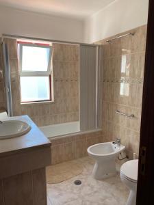 a bathroom with a toilet and a sink at Casa São Francisco in Porto Covo +12 photos