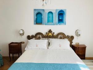 een slaapkamer met een bed met blauwe en witte kussens bij Villa Provenzale in Sanremo