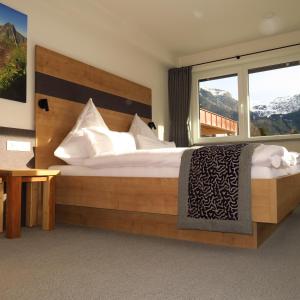 een slaapkamer met een groot bed met een groot raam bij Fellhorn Ferienwohnungen in Oberstdorf