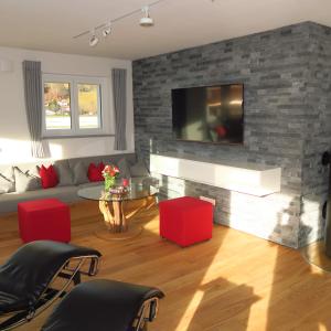een woonkamer met een tv aan een bakstenen muur bij Fellhorn Ferienwohnungen in Oberstdorf