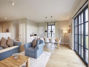 a living room with two blue couches and a table at Reetland am Meer - Luxus Reetdachvilla mit 3 Schlafzimmern, Sauna und Kamin F12 in Dranske