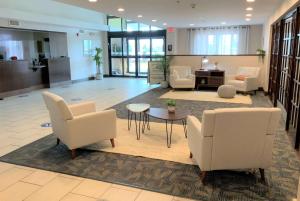 a lobby with chairs and a table in a building at Wingate by Wyndham Jackson Ridgeland in Ridgeland