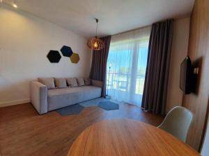 - un salon avec un canapé et une table dans l'établissement Prywatne apartamenty w hotelu - 365PAM, à Sarbinowo