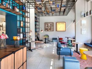 a restaurant with chairs and tables in a room at Hôtel ibis Styles Clermont-Ferrand Gare in Clermont-Ferrand