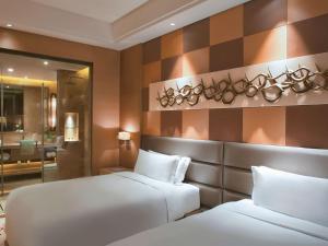 En eller flere senge i et værelse på Movenpick Hotel Enshi