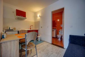 a small kitchen with a table and a bathroom at Vila Alba Brasov in Braşov