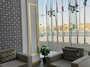 فندق سماء إن في الرياض: غرفة بها كرسيين ونافذة بها اعلام