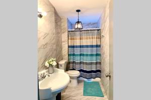 a bathroom with a sink and a toilet and a shower at 5BR Niagara Getaway Prime Location-Sleeps 10 in Niagara Falls +12 photos