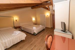 a hotel room with two beds and a television at Hotel Pallanza in Verbania