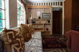 a living room with a couch and a book shelf at Honey Farm Country Get Away in Skeerpoort