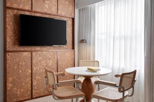 a room with a table and chairs and a tv on a wall at Lyle DC in Washington