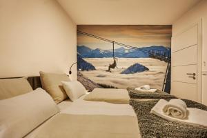 タウプリッツにあるdie Tauplitz Lodges - Adler Auszeit Lodge D6 by AA Holiday Homesのブランコの男絵付き寝室
