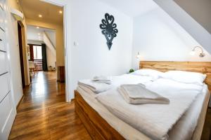 a bedroom with a large bed with white sheets at RentPlanet - Apartamenty Bulwary Słowackiego in Zakopane