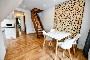 a kitchen and dining room with a white table and chairs at RentPlanet - Apartamenty Bulwary Słowackiego in Zakopane