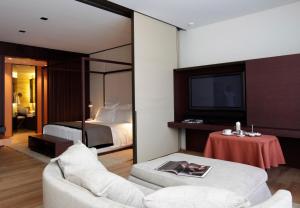 a bedroom with a bed and a tv and a couch at Barvikha Hotel & Spa - The Leading Hotels of the World in Barvikha