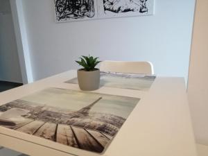 a white table with a potted plant on top of it at Apartment EG in Oststeinbek