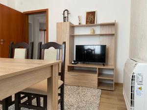 ein Wohnzimmer mit einem Tisch und einem TV in der Unterkunft Apartment Kirili and Metodi 41-8 in Berkowiza