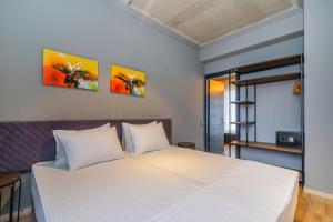 a bedroom with a white bed with two paintings on the wall at Magnetic Resort Ureki in Ureki