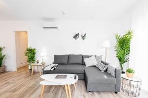 uma sala de estar com um sofá cinzento e uma mesa em Apartamentos Toboso Plaza em Nerja