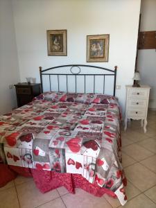 a bedroom with a bed with a red and white quilt at Fattoria San Vincenzo in Marina di Grosseto