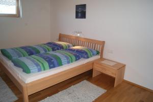 ein Bett mit zwei Kissen und einem Tisch in einem Zimmer in der Unterkunft Haus Eberle in Hittisau