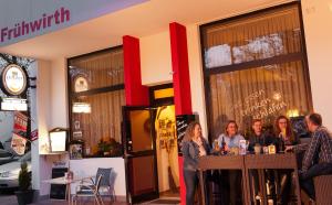 eine Gruppe von Leuten, die in einem Laden an einer Bar stehen in der Unterkunft Pension Frühwirth in Bad Tatzmannsdorf