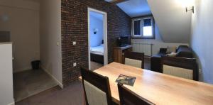 a room with a dining table and a brick wall at Lonka apartman Kopaonik in Kopaonik